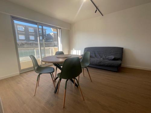 un salon avec une table, des chaises et un canapé dans l'établissement appartement cosy à 100m de la mer !, à Cucq
