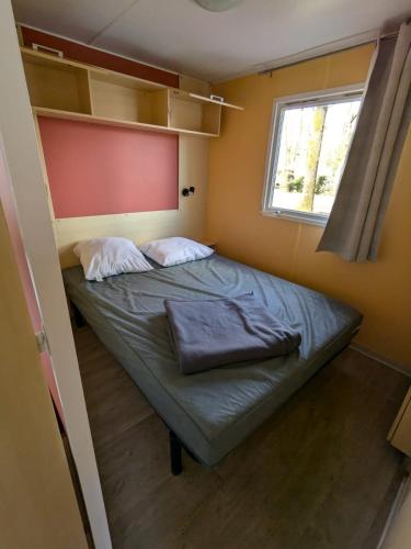 - un petit lit dans une petite chambre avec fenêtre dans l'établissement MH Topconfort 2ch 5pers 900DA, à La Boissière-de-Montaigu