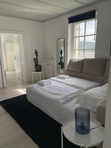 una camera da letto bianca con un letto e un divano di Rosenvilla Velden a Velden am Wörthersee