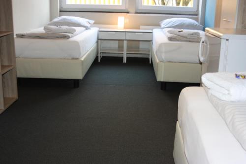 a room with three beds and a desk at Ahoi-Gästehaus in Hamburg