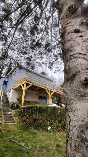 a house with a wooden deck next to a tree at Maison avec vue sur mer in Saint-Martin-Plage