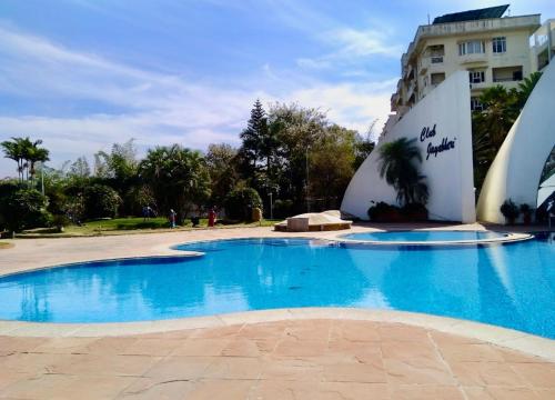 a large blue swimming pool in front of a building at Cozycasa By Nattis group 4 BR - Jacuzzi & private garden in Kondapur