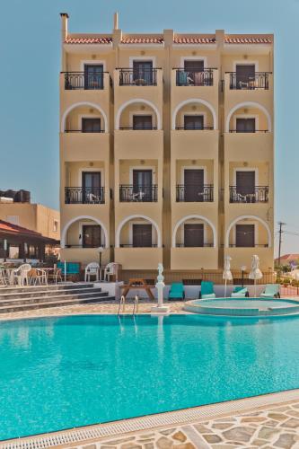 a hotel with a swimming pool in front of a building at Blue Bay Hotel in Karpathos Town
