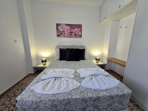 una camera da letto con un letto grande con due cuscini di Maraki's Little House Santorini a Kamari