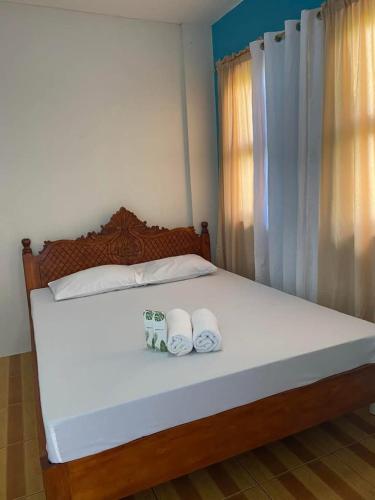a bedroom with a bed with two towels on it at Hollanda Recidencia Apartment Hotel in Bangued