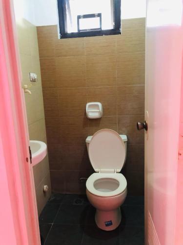 a small bathroom with a toilet and a window at Hollanda Recidencia Apartment Hotel in Bangued