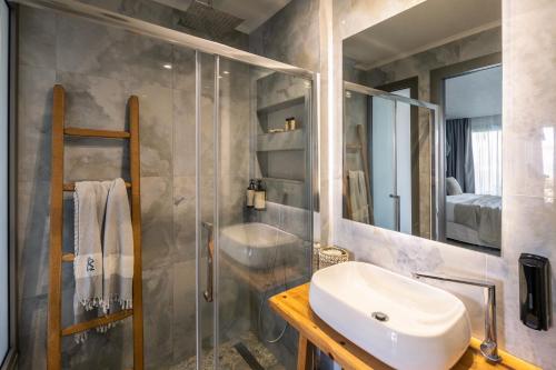a bathroom with a sink and a glass shower at Blue Carpet Luxury Suites in Pefkohori