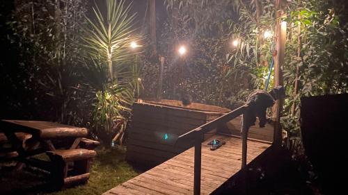 a wooden deck with a jacuzzi in a garden at night at Bosques del Paico in El Monte