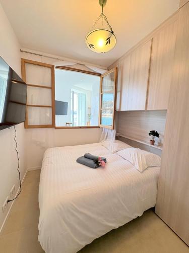 une chambre avec un grand lit blanc avec une fenêtre dans l'établissement NEPTUNE AP4453 By Riviera Holiday Homes, à Villefranche-sur-Mer