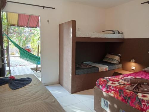 a bedroom with two bunk beds and a hammock at Villa wagmaker Jesús está voltando in São Miguel do Gostoso