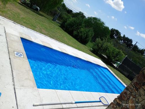 una piscina azul al lado de una acera en CASA QUINTA CON ESPECTACULAR VISTA Al RÍO, en General Alvear
