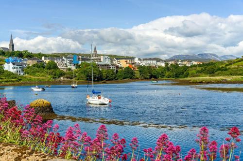 a boat in a river with a city in the background at Apartment 297 - Clifden in Clifden