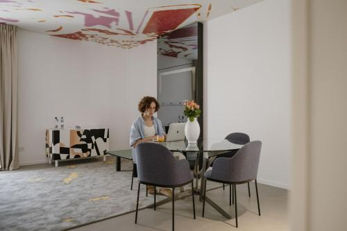 a woman sitting at a table with a laptop at Biancodonda Greenblu Hotel & SPA in Gallipoli