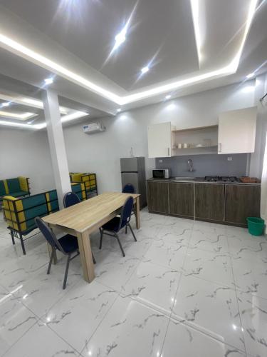 a room with a table and chairs and a kitchen at Mondialaw in Toubab Dialaw