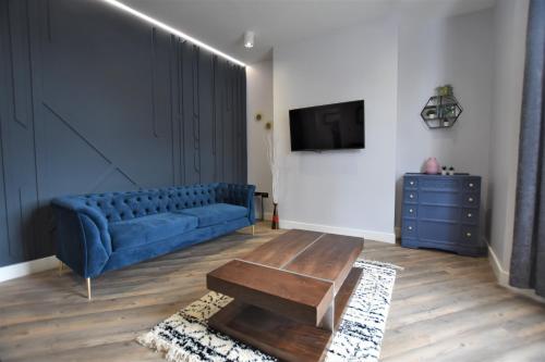 a living room with a blue couch and a table at Central, Contractor&Family Friendly, SmartTV in Sunderland