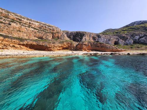 a body of water next to a rocky beach at Casa Cortile Nonna Caterina in Valderice