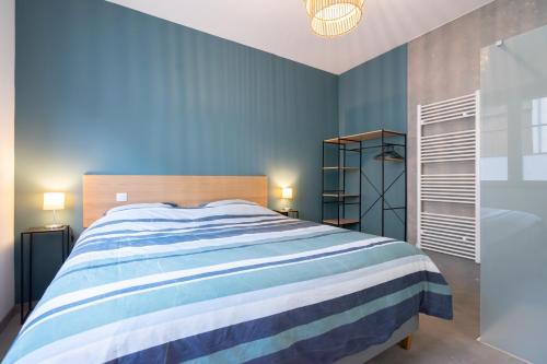 a bedroom with a blue and white striped bed at La Rocha in La Roche-en-Ardenne