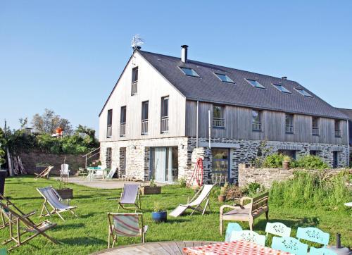 a large white building with chairs in front of it at Chambre Guernesey - Quai des Ormes in Barneville-Carteret