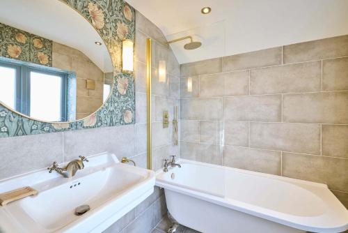 a bathroom with a sink and a tub and a mirror at Host & Stay - The Lodge in Whitby