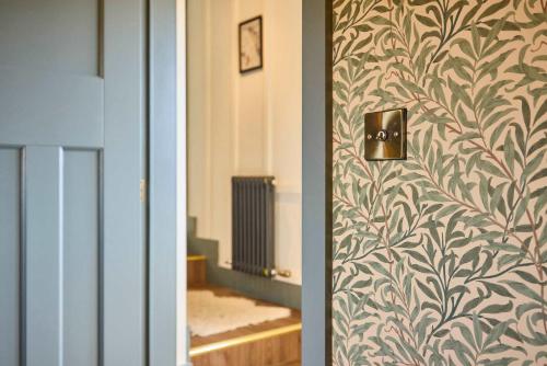 a door with a wall with a leafy wallpaper at Host & Stay - The Lodge in Whitby