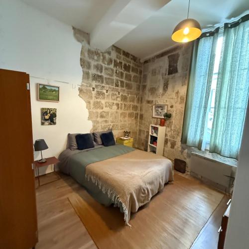 une chambre avec un lit et un mur de briques dans l'établissement Chic Renovation of Medieval Monastery, à Montpellier