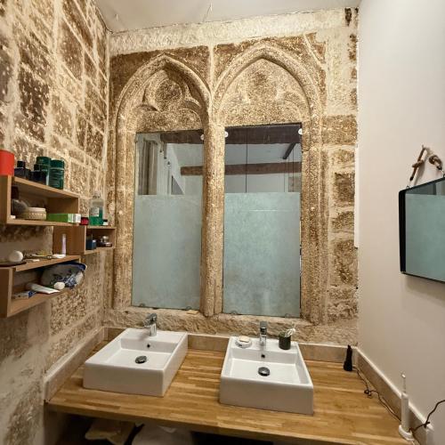 une salle de bain avec deux lavabos et une fenêtre dans l'établissement Chic Renovation of Medieval Monastery, à Montpellier