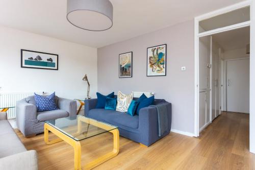 a living room with a blue couch and a table at Spacious Central 3 Bedroom Apartment in Old Street in London