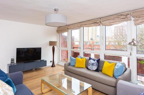 a living room with a couch and a tv at Spacious Central 3 Bedroom Apartment in Old Street in London