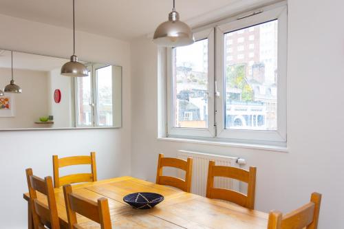 a dining room with a wooden table and chairs at Spacious Central 3 Bedroom Apartment in Old Street in London