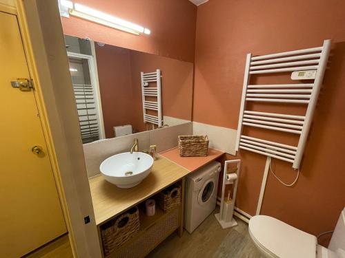 une salle de bain avec un lavabo et un miroir dans l'établissement L'escapade Marine, au Cap d'Agde