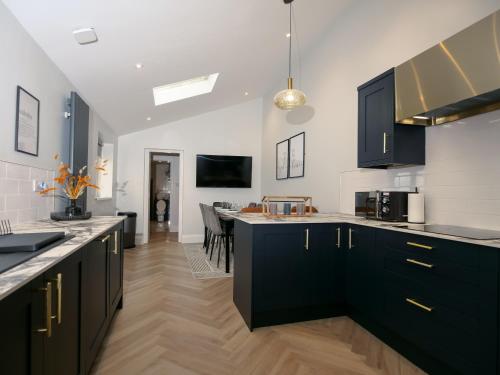a kitchen with black cabinets and a dining room at Dwell Living Luxurious 5BD House Central in Sunderland