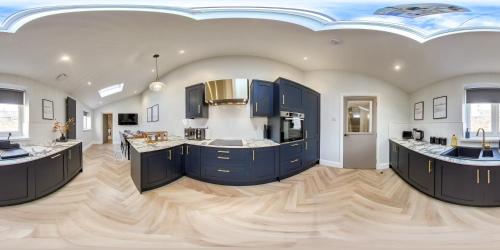 a kitchen with blue cabinets and two sinks at Dwell Living Luxurious 5BD House Central in Sunderland
