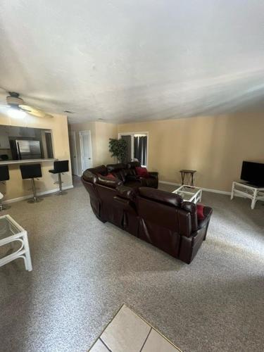 a living room with a brown leather couch in a room at The Moorings Hotel and Marina of Carrabelle in Davis Island