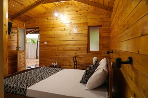 a bedroom with a bed in a wooden cabin at Eiffel Sea Resort in Trincomalee