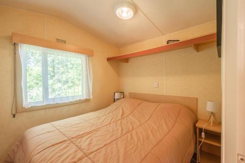 une petite chambre avec un lit et une fenêtre dans l'établissement Mh 227 Les 3 coups aux Mathes, aux Mathes