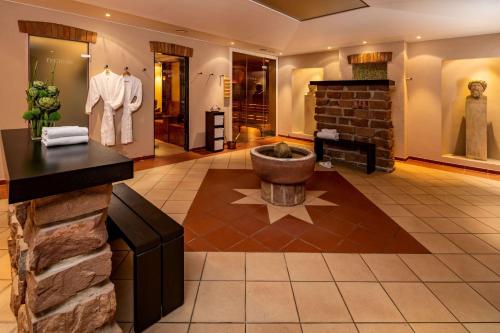 a large room with a stone fireplace and a stone wall at Park Plaza Trier in Trier