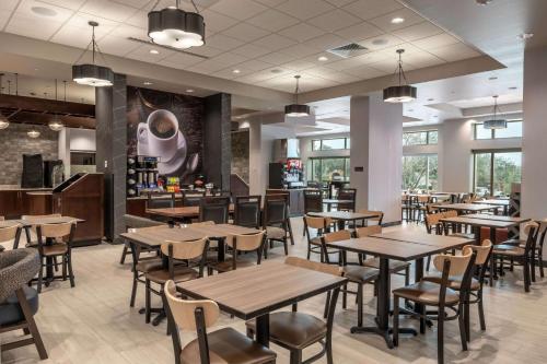 a restaurant with tables and chairs and a bar at Drury Plaza Hotel College Station in College Station