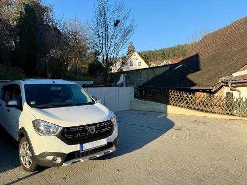 a white car is parked in a driveway at Boardinghouse Zur Rose in Leidersbach