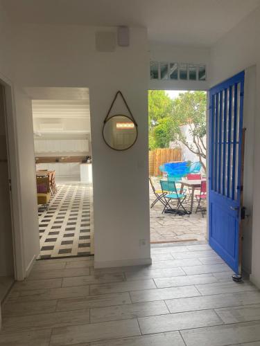 un couloir avec une porte bleue et une terrasse dans l'établissement Location maison l'embellie, à La Tremblade