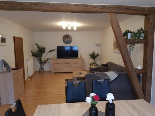 a living room with a blue couch and a tv at Ferienhaus Zimmer in Perl