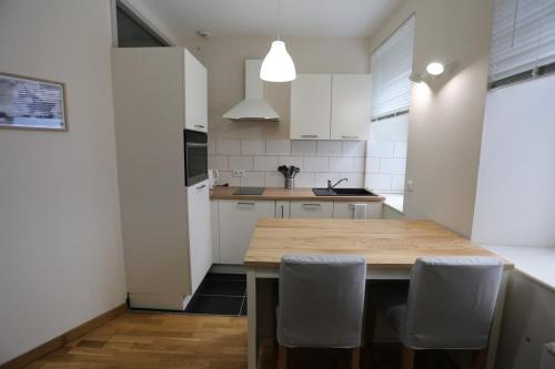 a kitchen with a wooden table and white cabinets at Joli appartement au centre de Brest in Brest