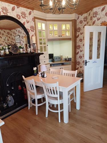 a kitchen with a table and chairs and a fireplace at Sleepy Hollow B&B in Donegal