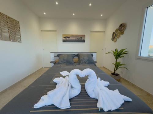 ein Schlafzimmer mit einem Bett mit Handtüchern in Herzform in der Unterkunft Villa Harmonie - Luxe, Jaccuzzi et Piscine en Charente-maritime in Saint-Ciers-du-Taillon