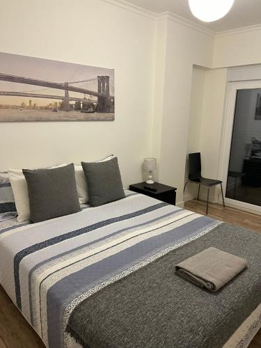 a bedroom with a large bed with a painting on the wall at Modern Big Room with Balcony in New Apartment in Montijo