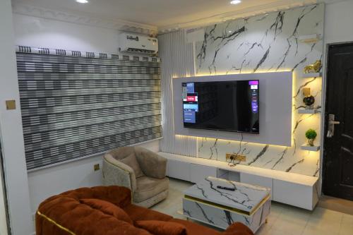 a living room with a tv on a wall at Grace On Wallstreet Apartments in Otta