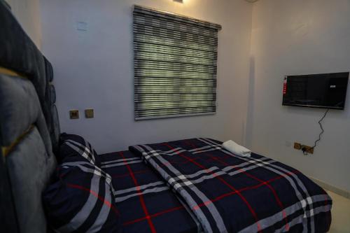 a bedroom with a bed with a plaid blanket at Grace On Wallstreet Apartments in Otta
