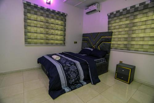 a bedroom with a bed in a room with purple lights at Grace On Wallstreet Apartments in Otta