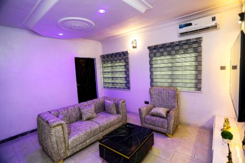 a living room with a couch and two chairs at Grace On Wallstreet Apartments in Otta