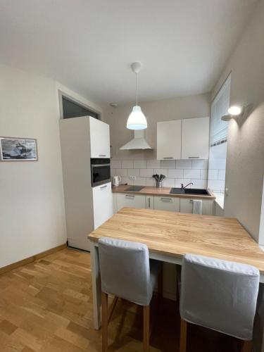 a kitchen with a wooden table and white cabinets at Joli appartement au centre de Brest in Brest