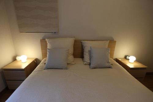 a bedroom with a bed with two lights on it at Joli appartement au centre de Brest in Brest